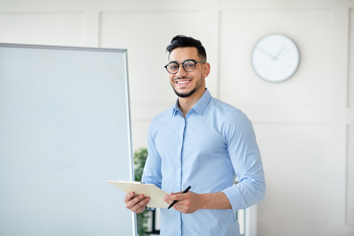 arab-male-teacher-standing-near-empty-blackboard-2021-12-09-08-17-52-utc arab-male-teacher-standing-near-empty-blackboard-2021-12-09-08-17-52-utc