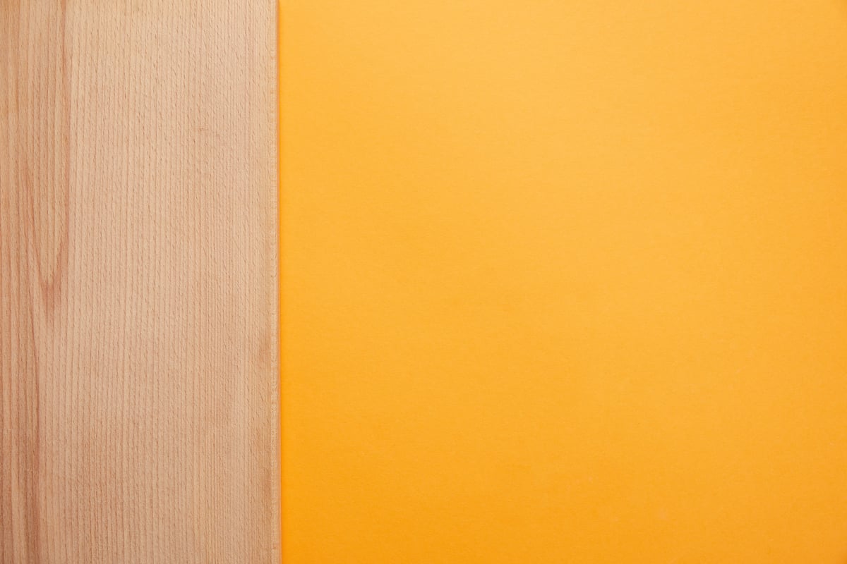 top-view-of-bright-orange-background-and-wooden-su-2021-08-29-22-51-11-utc